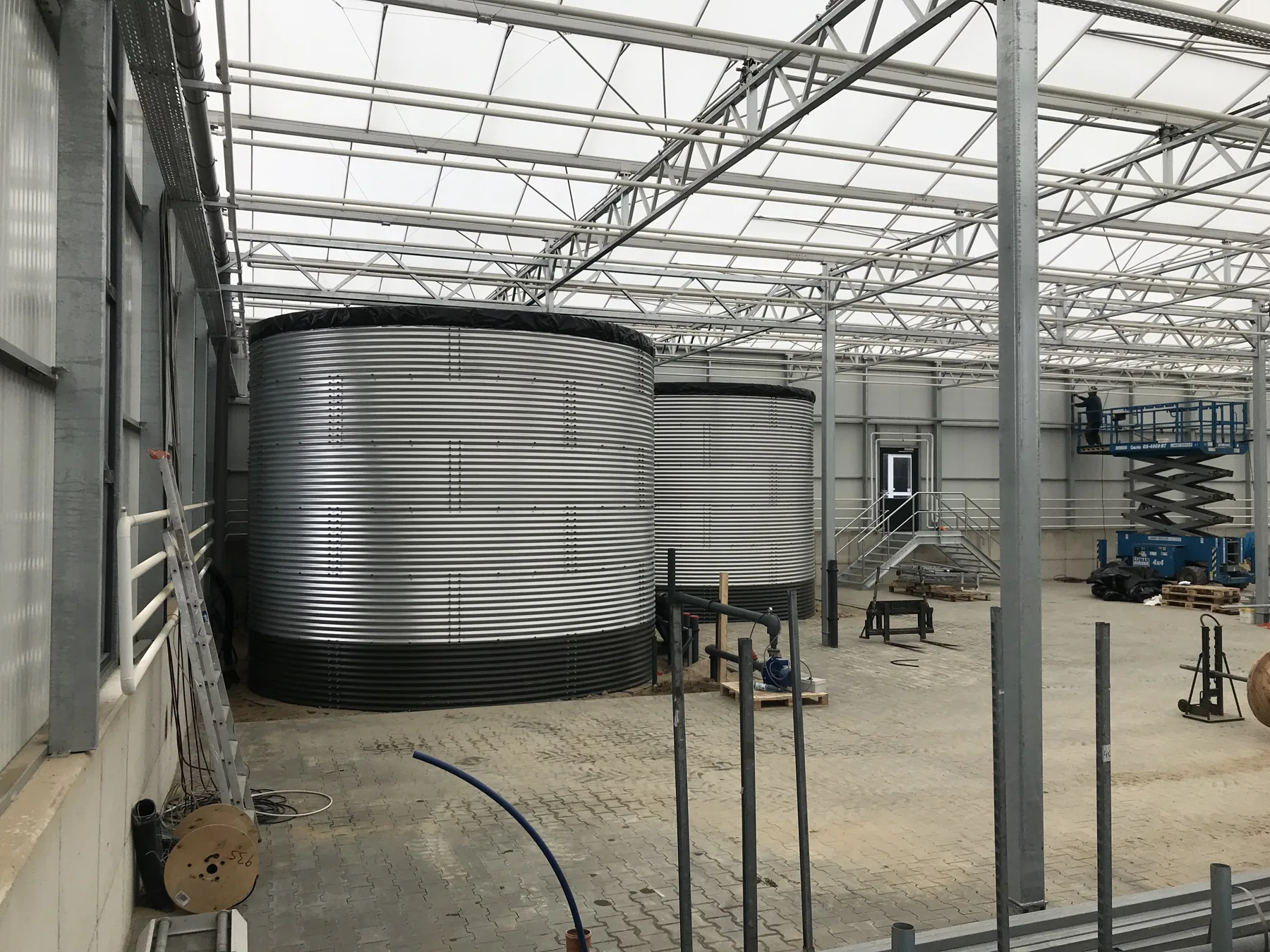 Twee gegalvaniseerde opslagtanks in een nieuwe kas